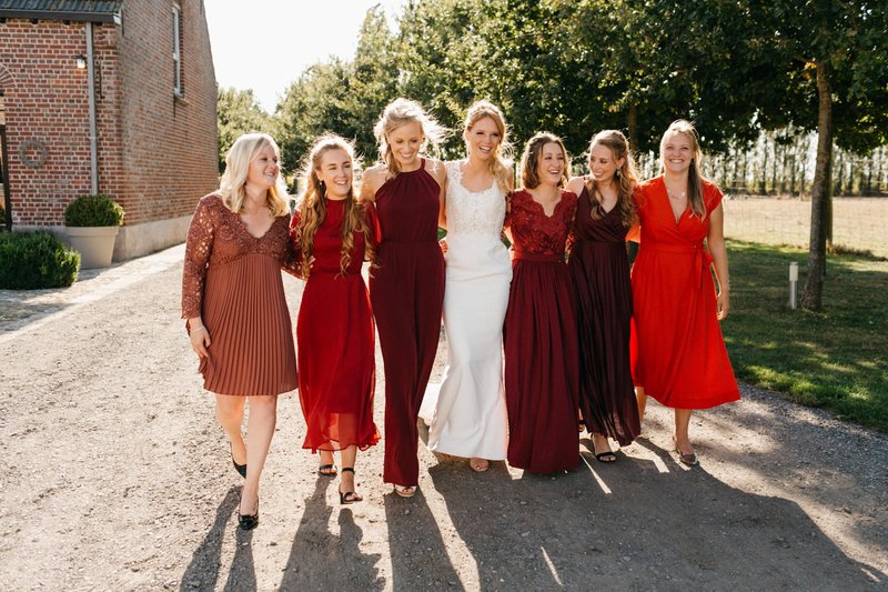 Een%20bruid%20met%20haar%20bruidsmeisjes%20in%20rode%20jurken%20-%20House%20of%20Weddings