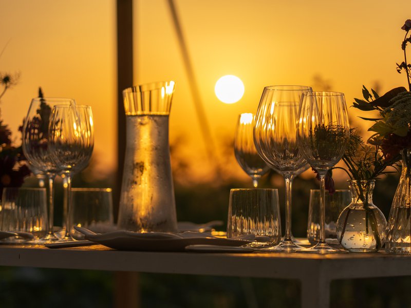 Een%20close-up%20van%20glazen%20en%20servies%20op%20een%20gedekte%20tafel%20door%20Femat%20-%20House%20of%20Weddings