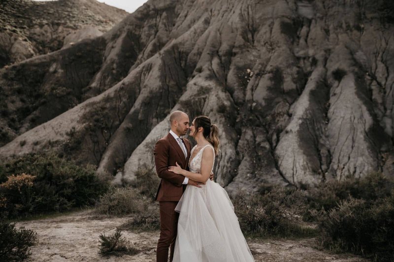 Een%20kostuum%20in%20aardetinten%2C%20deel%20van%20de%20trouwkostuum%20trends%20voor%202025%20-%20House%20of%20Weddings