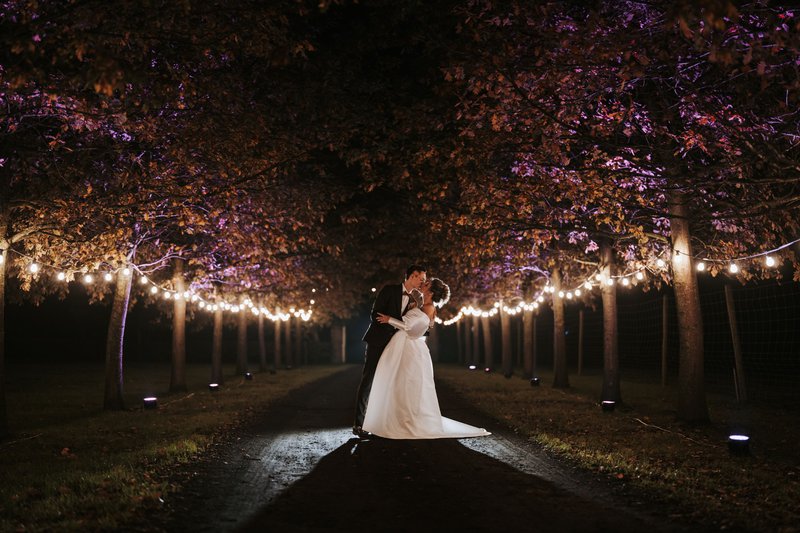 Pauline%20en%20Lukas%20in%20een%20mooi%20verlichte%20bomenlaan%20-%20House%20of%20Weddings